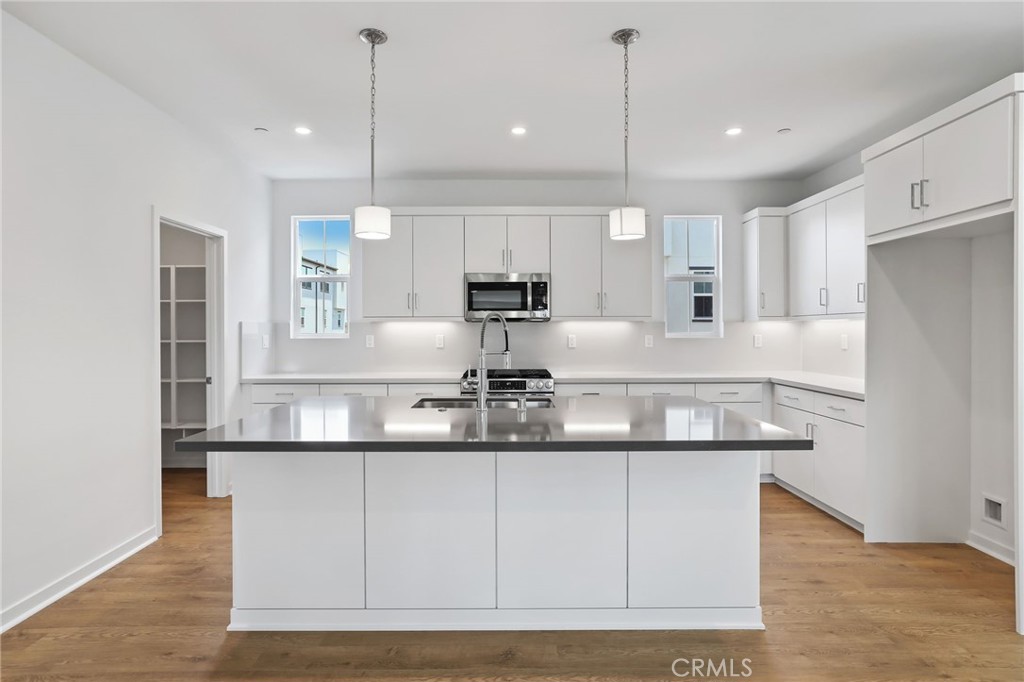 139 Jessup Way Tustin, CA 92780 - Photo 9 of 31 a kitchen with kitchen island stainless steel appliances a sink and refrigerator