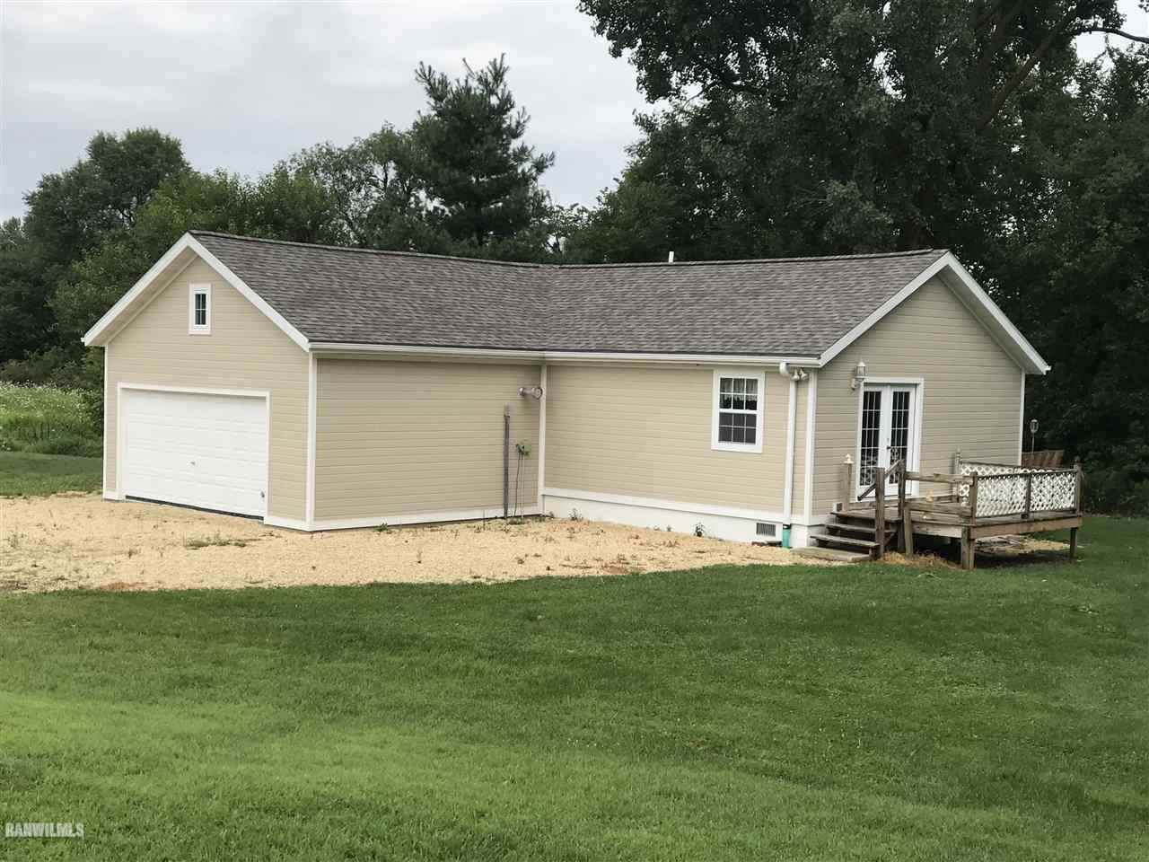 7985 Haas Road Savanna, IL 61074 - Photo 1 of 17 a front view of a house with a garden and yard