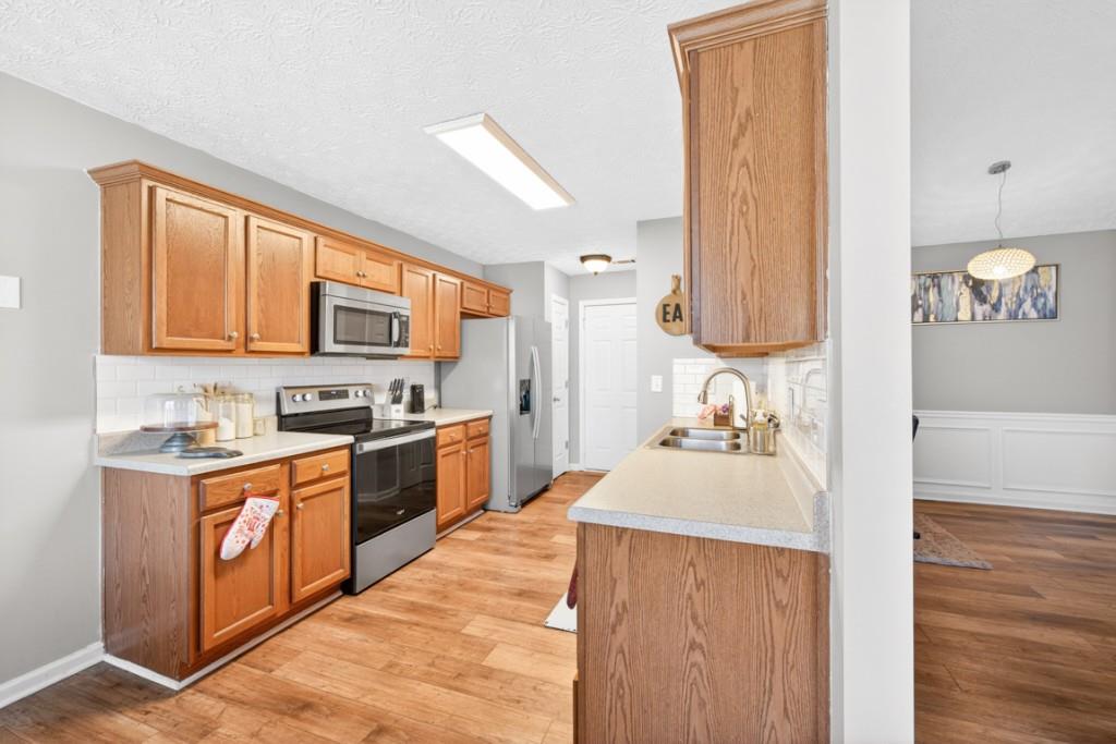 1501 Cardinal Lane Winder, GA 30680 - Photo 12 of 33 a kitchen with stainless steel appliances granite countertop a sink stove and refrigerator