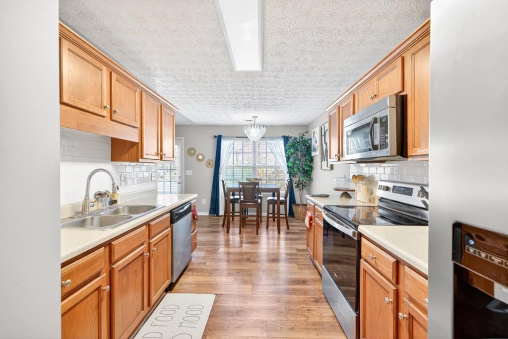 1501 Cardinal Lane Winder, GA 30680 - Photo 14 of 33 a kitchen with stainless steel appliances granite countertop sink stove top oven and cabinets