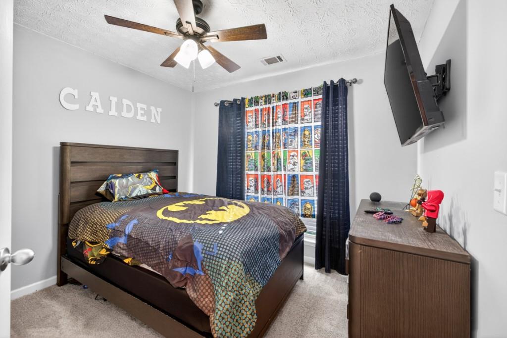 1501 Cardinal Lane Winder, GA 30680 - Photo 26 of 33 a bedroom with a bed a flat screen tv and a chandelier