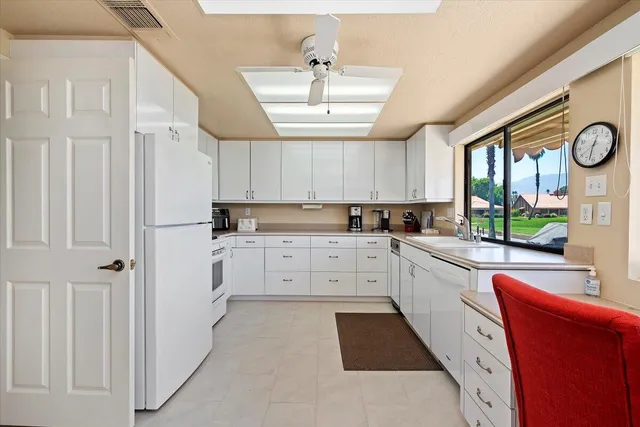 a kitchen with cabinets stainless steel appliances and a window