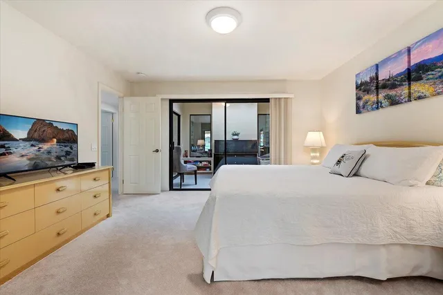 a spacious bedroom with a large bed and a dresser