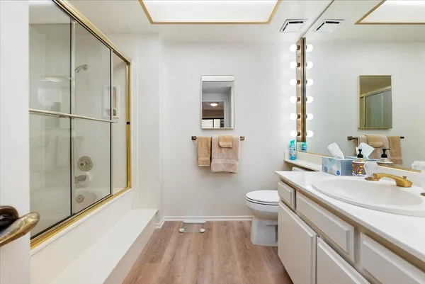 a bathroom with a sink a toilet and shower