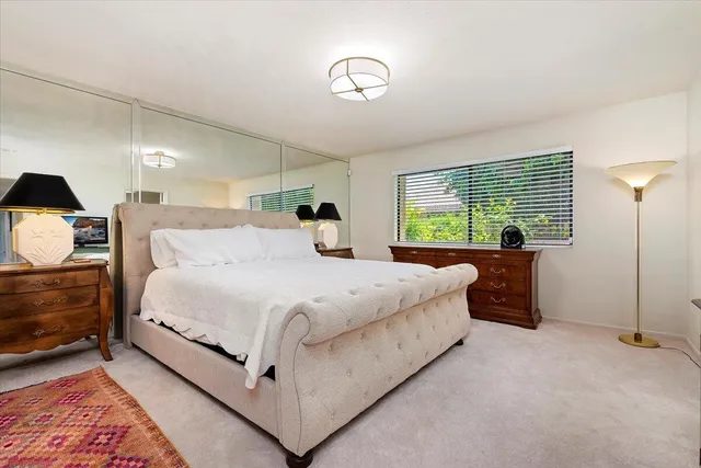 a bedroom with a bed and a large window