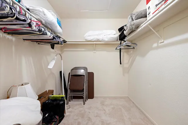 a view of walk in closet with clothes and shoes