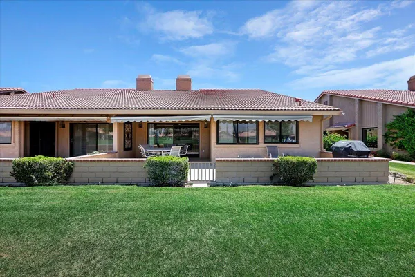 a front view of a house with a yard and plants