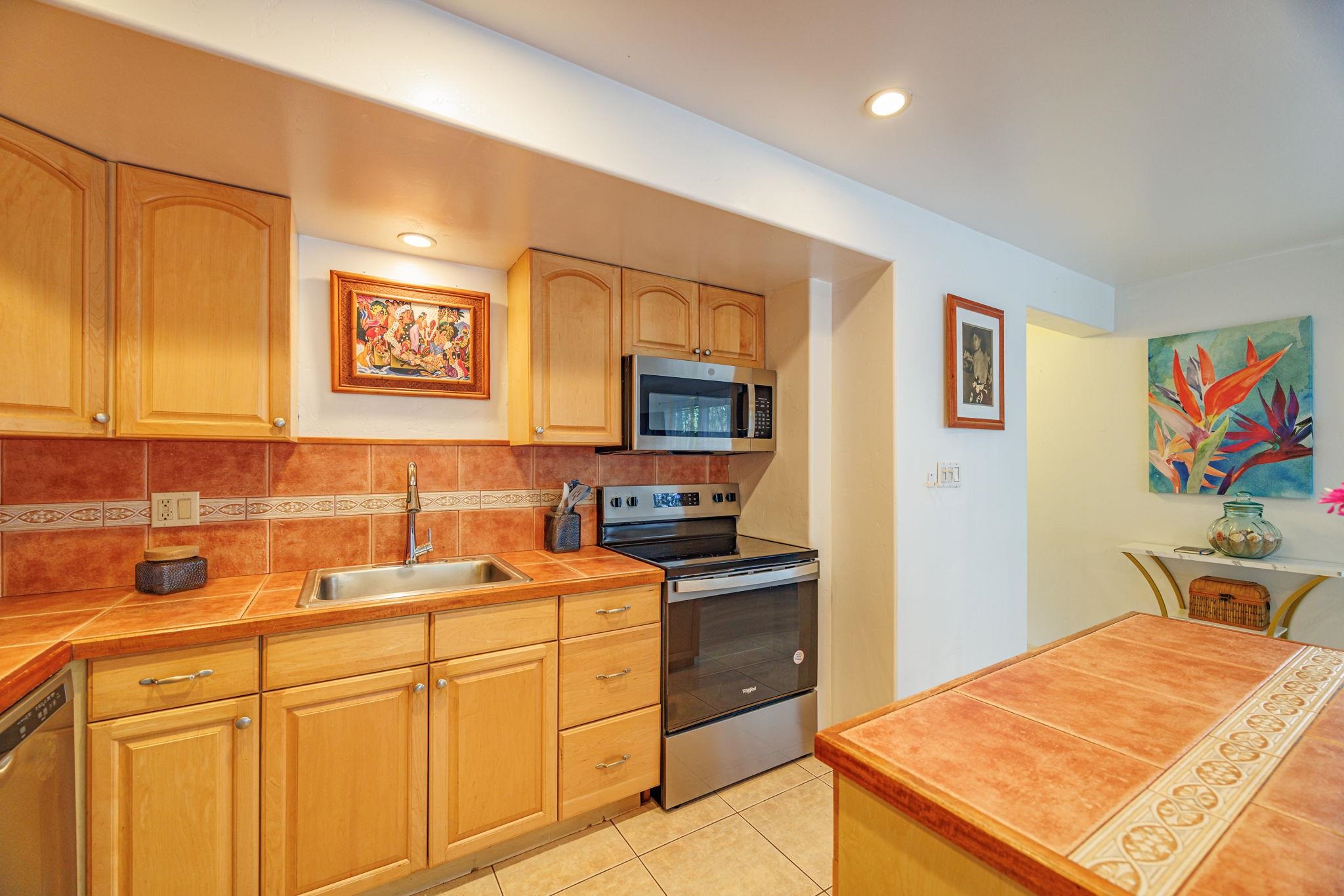 3559 Lower Honoapiilani Road, Unit 720 Lahaina, HI 96761 - Photo 11 of 31 a kitchen that has a sink and a stove in it