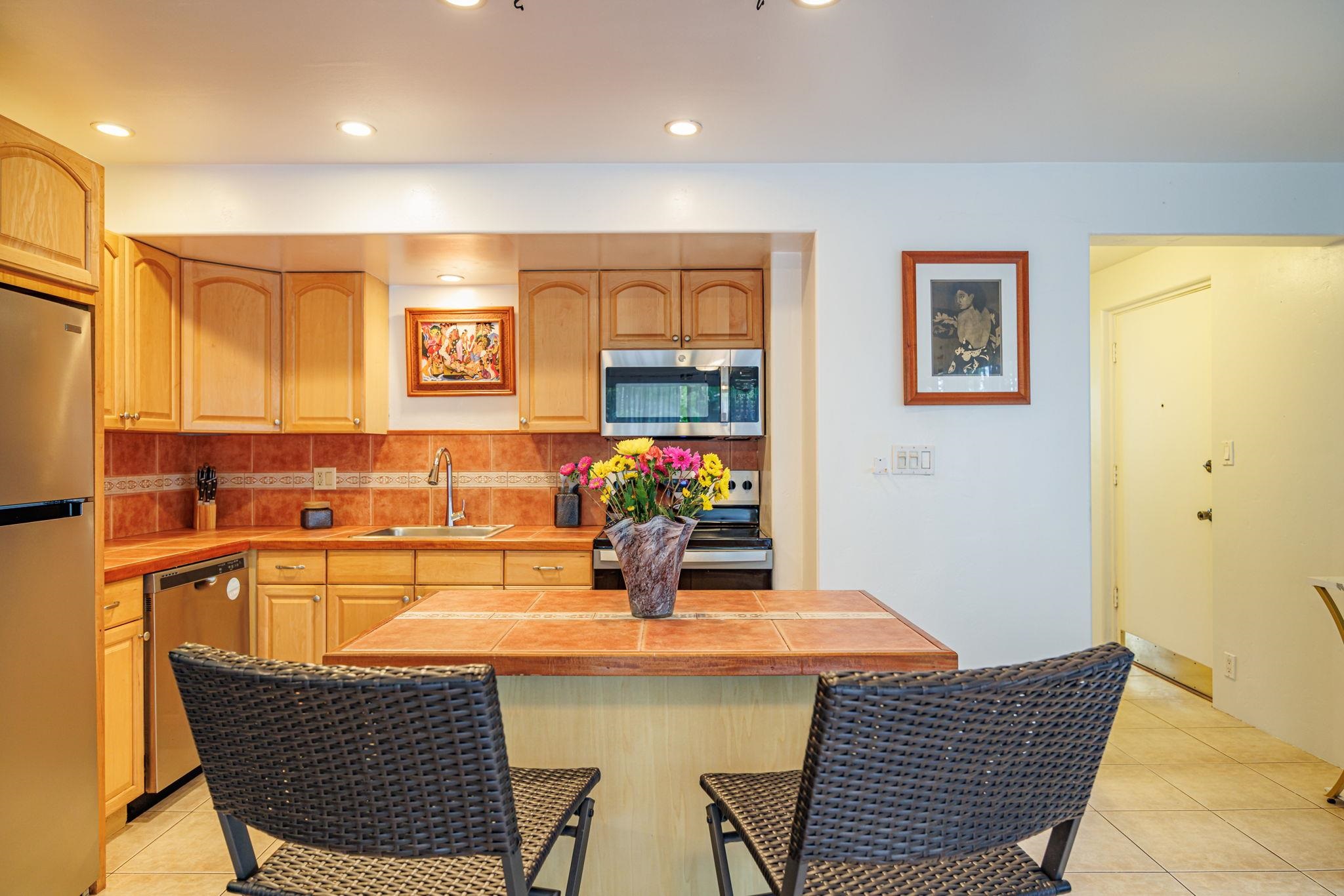 3559 Lower Honoapiilani Road, Unit 720 Lahaina, HI 96761 - Photo 14 of 31 a kitchen with a table and chairs in it
