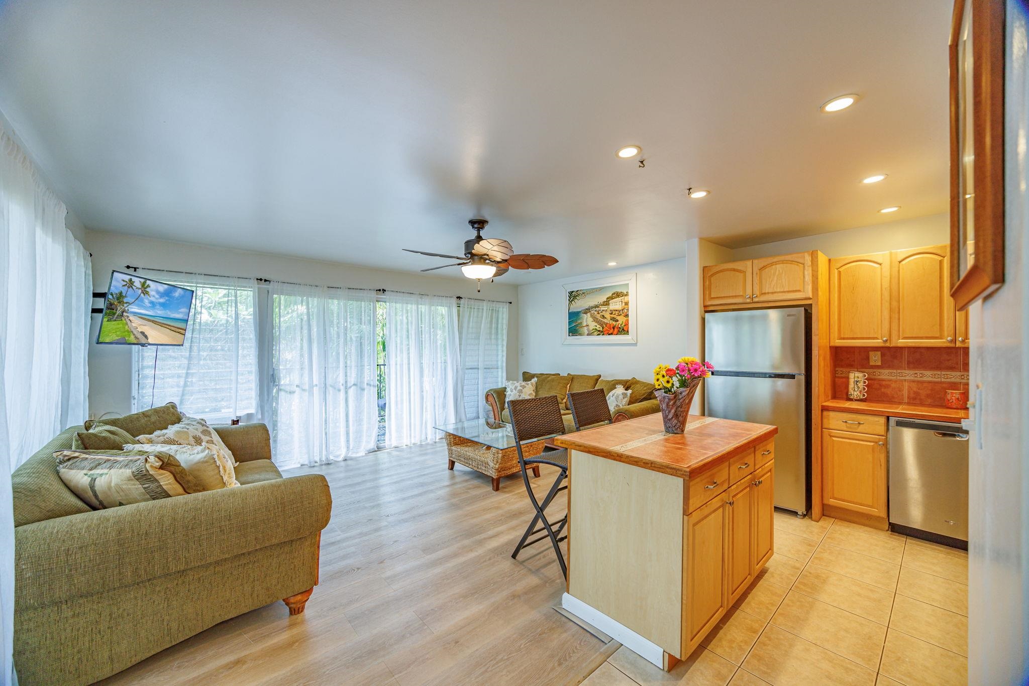 3559 Lower Honoapiilani Road, Unit 720 Lahaina, HI 96761 - Photo 6 of 31 a living room with stainless steel appliances kitchen island granite countertop furniture and a wooden floor