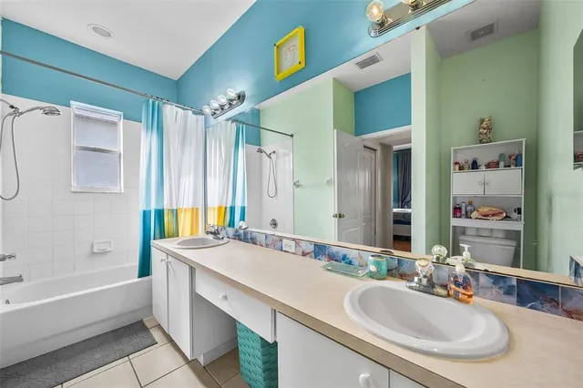 a bathroom with a granite countertop tub sink and mirror