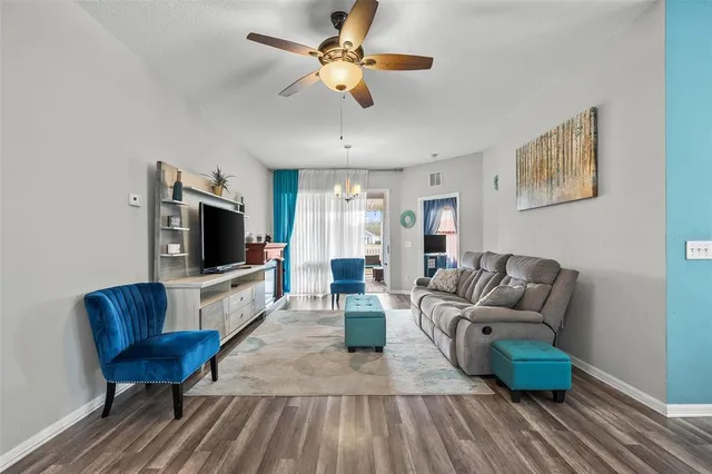 a living room with furniture a flat screen tv and a window
