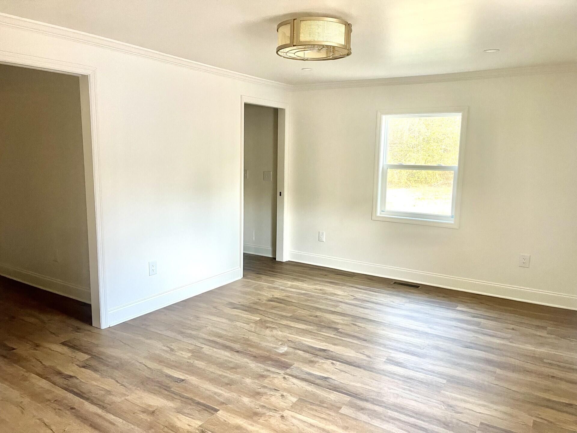 721 South Jackson Street Athens, TN 37303 - Photo 12 of 17 an empty room with wooden floor cabinet and windows