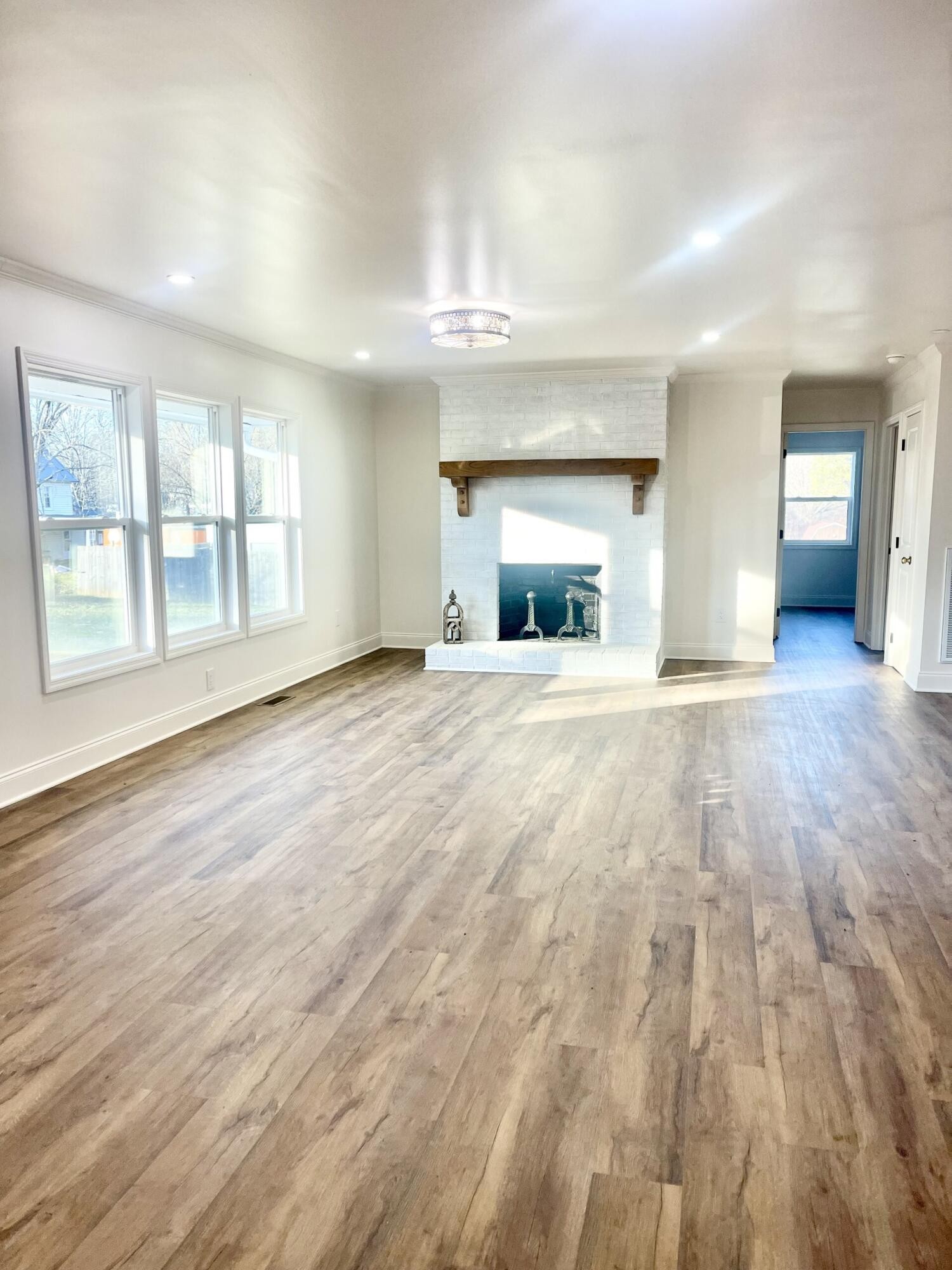 721 South Jackson Street Athens, TN 37303 - Photo 4 of 17 an empty room with wooden floor and a fireplace