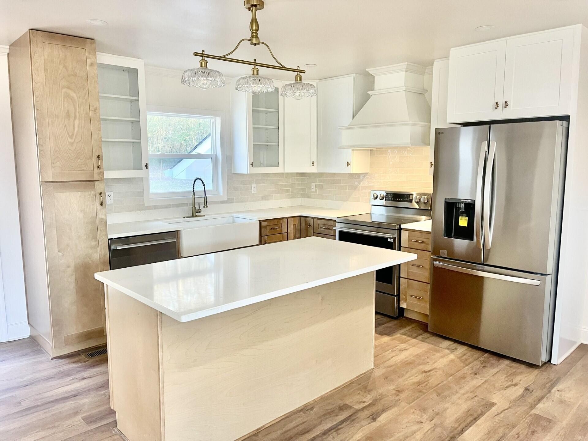 721 South Jackson Street Athens, TN 37303 - Photo 5 of 17 a kitchen with stainless steel appliances a refrigerator a sink a stove and white cabinets with wooden floor