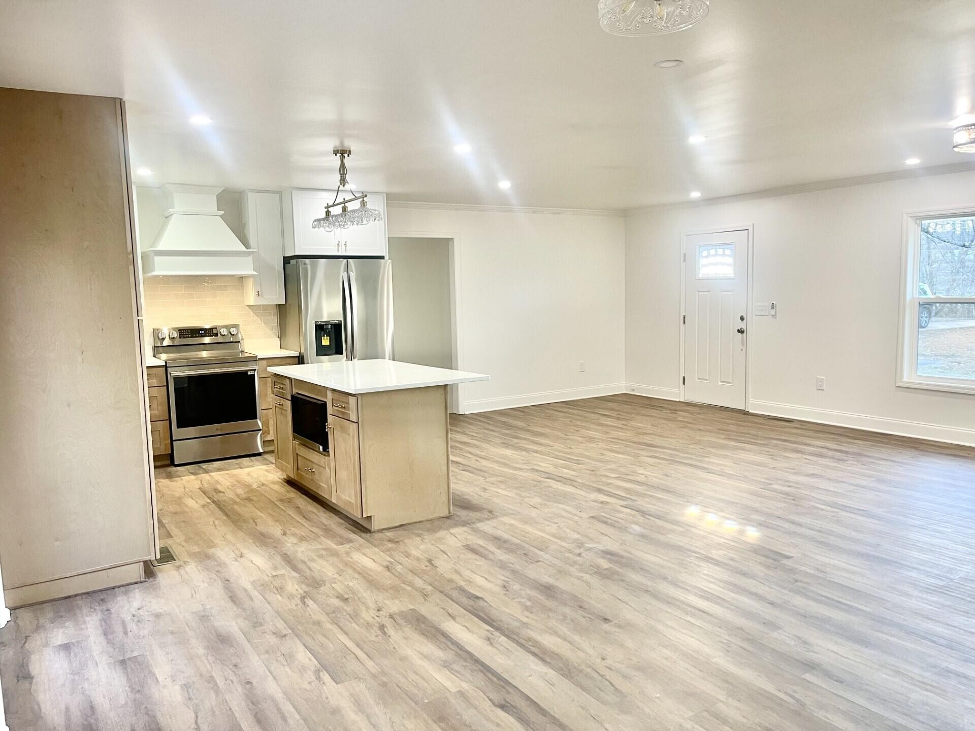 721 South Jackson Street Athens, TN 37303 - Photo 10 of 17 a large kitchen with stainless steel appliances granite countertop a sink and stove top oven with wooden floor