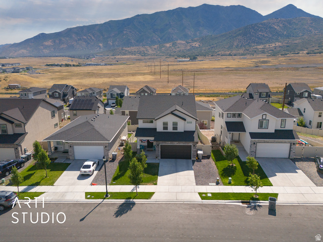 1713 South Windemere Road Santaquin, UT 84655 - Photo 36 of 40 Modern residential exterior featuring a light-colored facade with dark trim accents, a two-car garage, and a neatly landscaped front yard