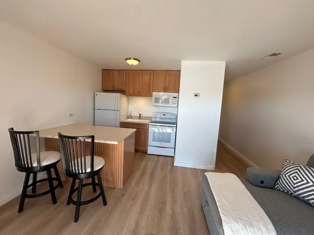 a kitchen with a table chairs and refrigerator