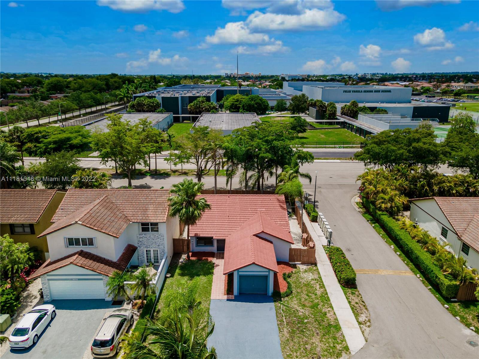 an aerial view of residential houses with outdoor space and ocean view