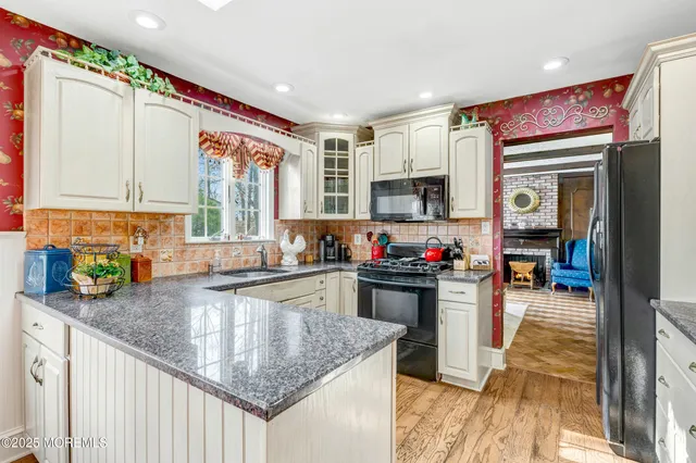 a kitchen with stainless steel appliances a sink window and cabinets