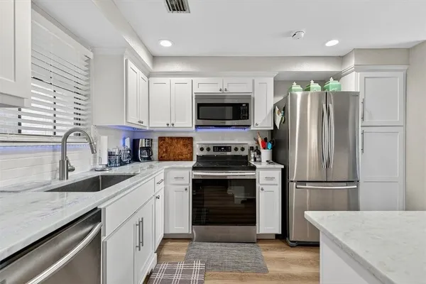 a kitchen with stainless steel appliances granite countertop a refrigerator stove and microwave