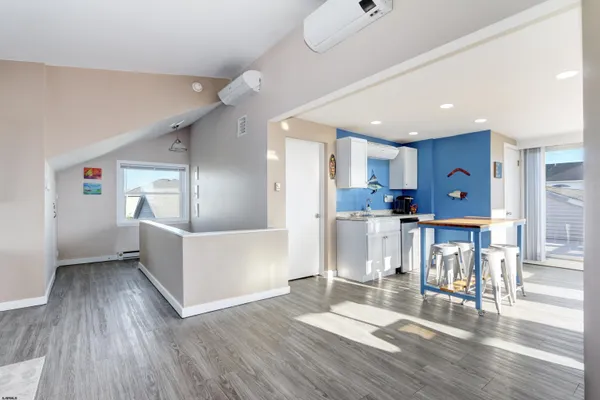 a view of a kitchen with furniture and wooden floor