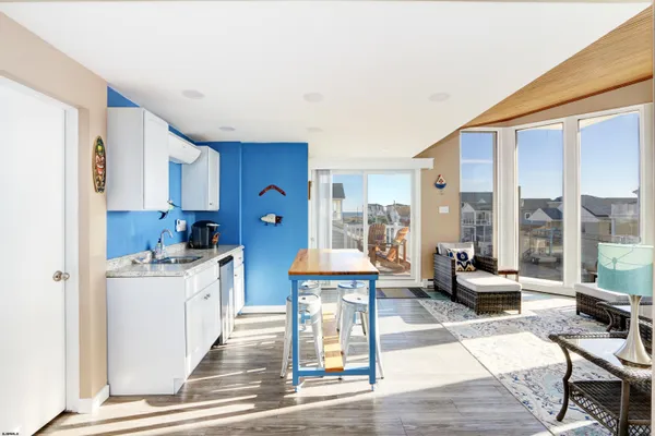 a living room with stainless steel appliances kitchen island granite countertop furniture and a wooden floor