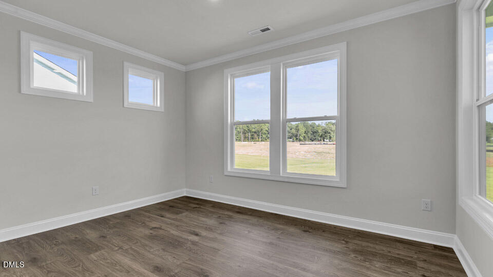 128 Gilmer Street Fuquay-Varina, NC 27526 - Photo 14 of 42 a view of an empty room with wooden floor and a window