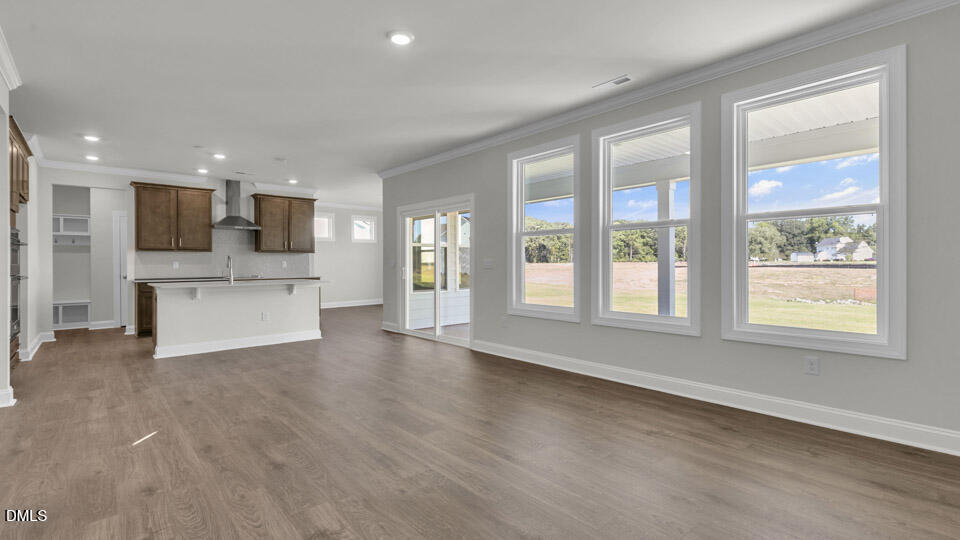 128 Gilmer Street Fuquay-Varina, NC 27526 - Photo 6 of 42 a view of an empty room with a kitchen and a window