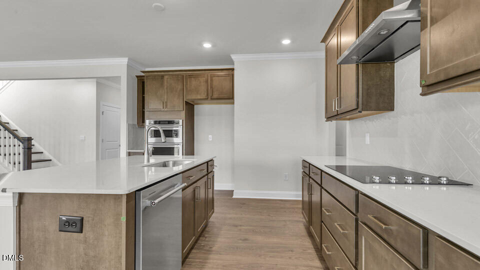 128 Gilmer Street Fuquay-Varina, NC 27526 - Photo 10 of 42 a kitchen with stainless steel appliances granite countertop a sink and a stove