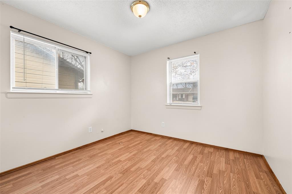 404 Vaden Avenue Everman, TX 76140 - Photo 11 of 16 a view of an empty room with wooden floor and a window