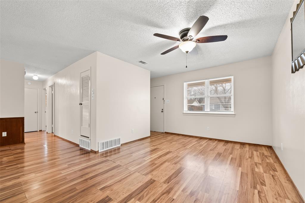 404 Vaden Avenue Everman, TX 76140 - Photo 3 of 16 a view of an empty room with wooden floor and a ceiling fan