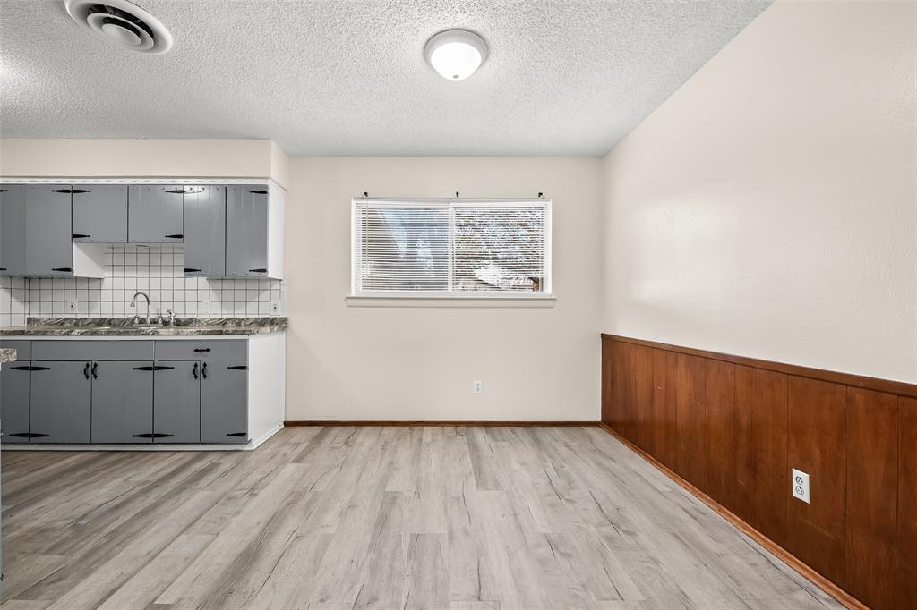 404 Vaden Avenue Everman, TX 76140 - Photo 6 of 16 a view of a kitchen with a sink and dishwasher with wooden floor