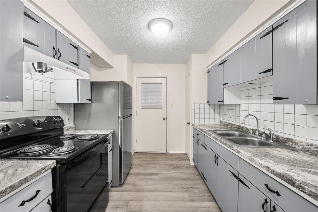 404 Vaden Avenue Everman, TX 76140 - Photo 7 of 16 a kitchen with stainless steel appliances granite countertop a sink stove and refrigerator