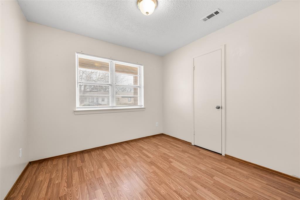 404 Vaden Avenue Everman, TX 76140 - Photo 9 of 16 an empty room with wooden floor and windows