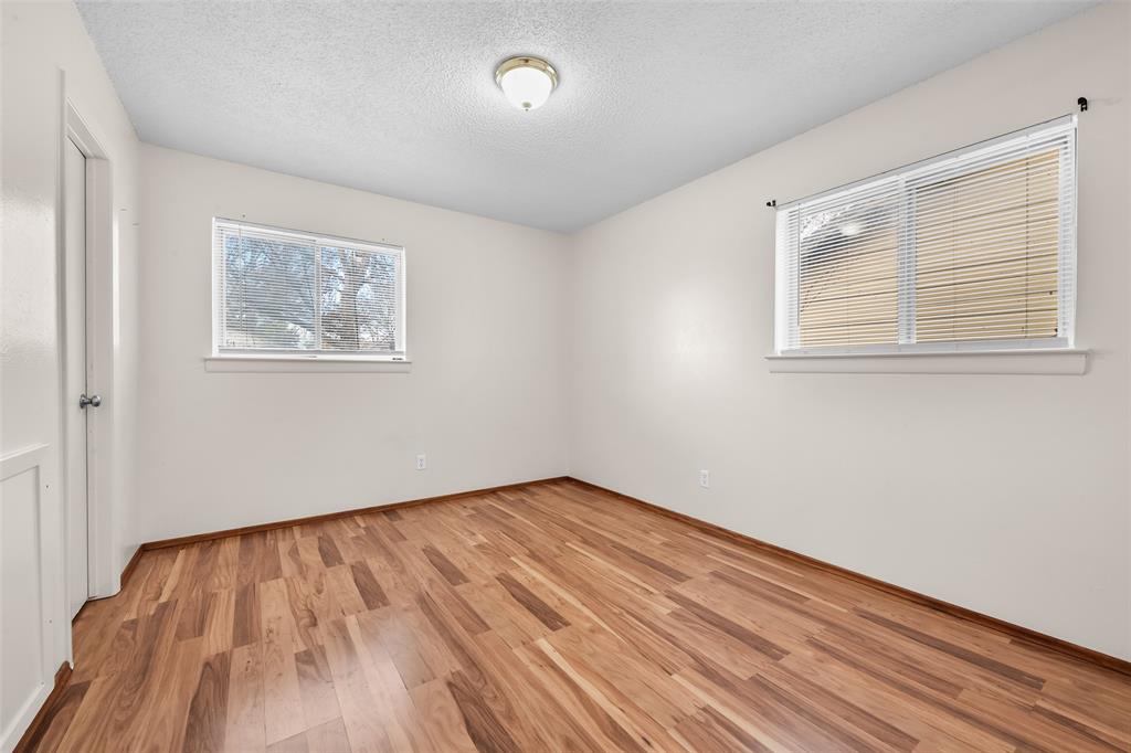 404 Vaden Avenue Everman, TX 76140 - Photo 10 of 16 a view of an empty room with wooden floor and a window