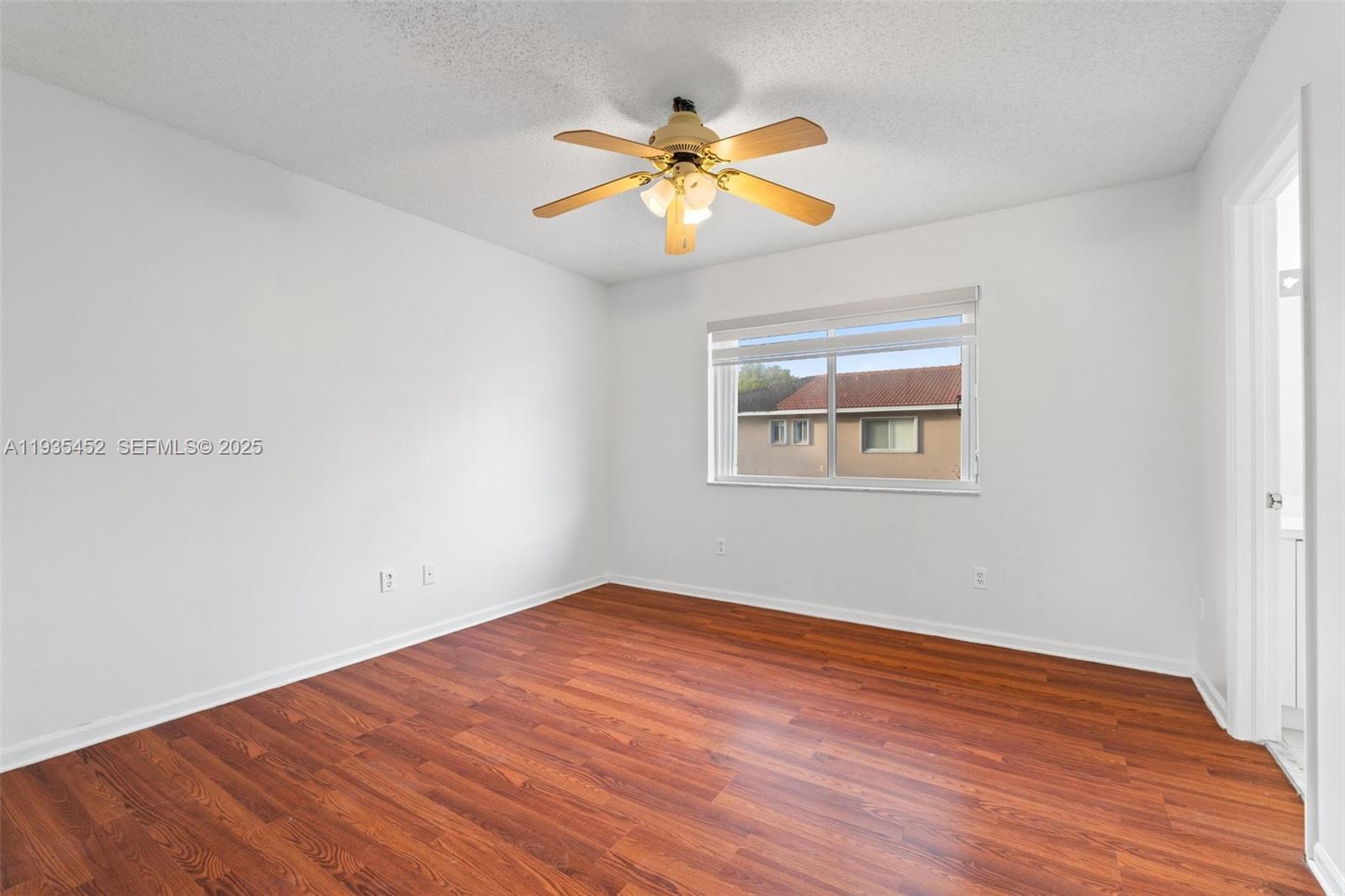 13925 Southwest 175th Terrace Miami, FL 33177 - Photo 12 of 20 wooden floor in an empty room with a window