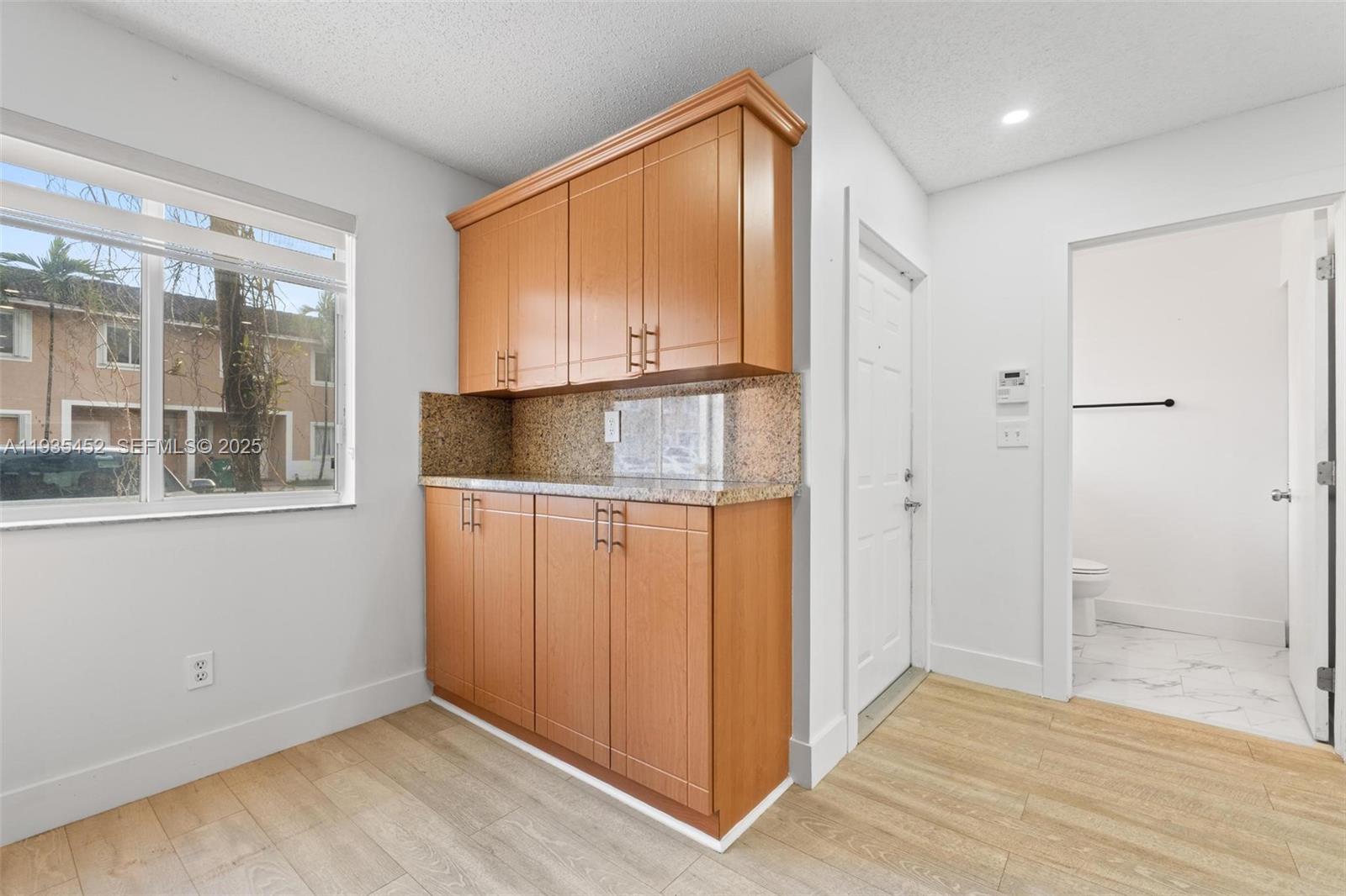 13925 Southwest 175th Terrace Miami, FL 33177 - Photo 4 of 20 a view of an empty room with wooden floor and a window