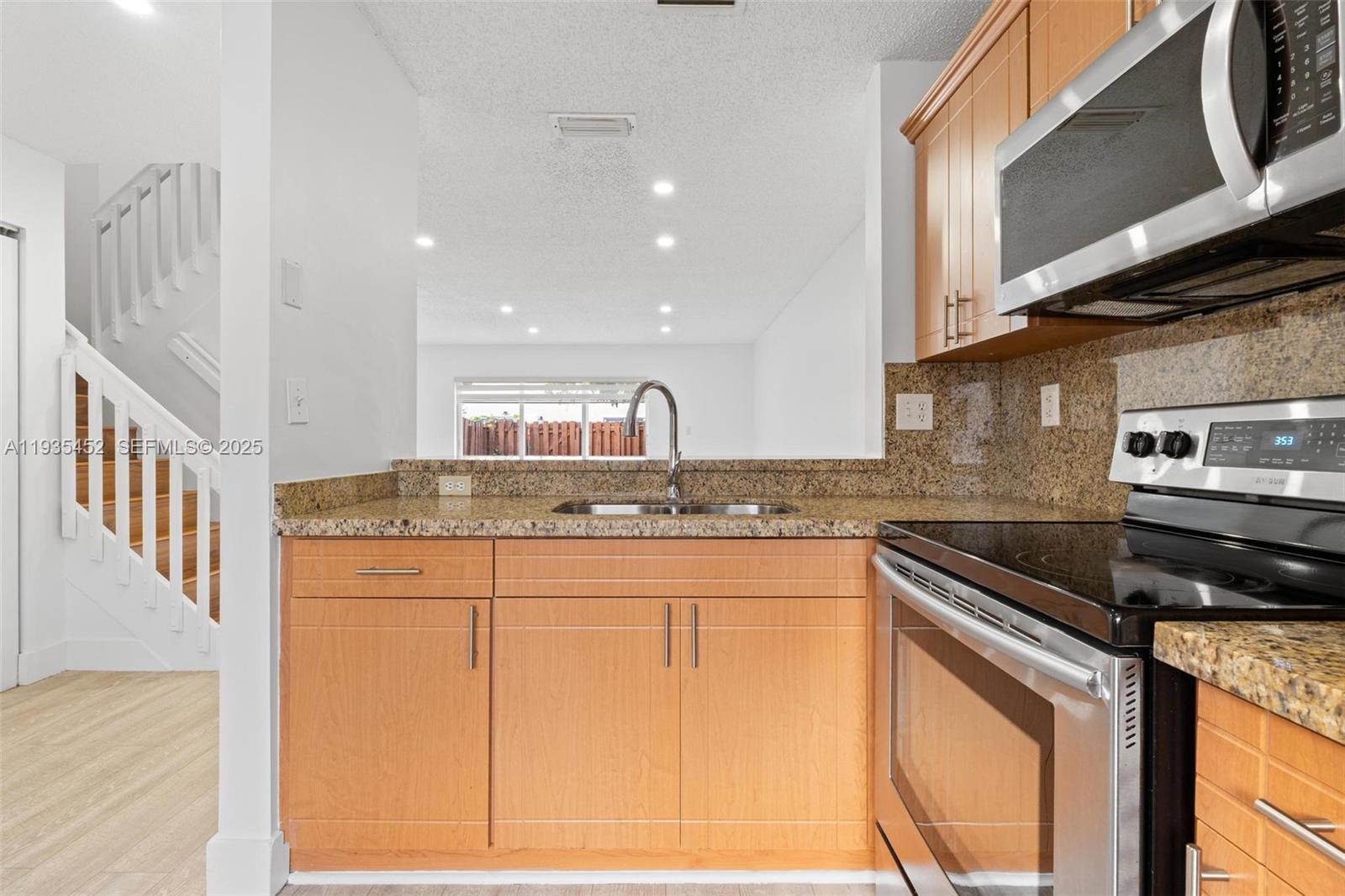 13925 Southwest 175th Terrace Miami, FL 33177 - Photo 5 of 20 a kitchen with granite countertop a sink and a stove