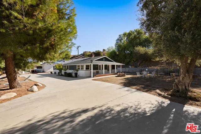 a white house with a large tree in front of it