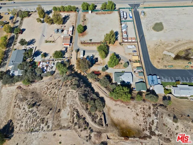 an aerial view of a house with a yard and large trees