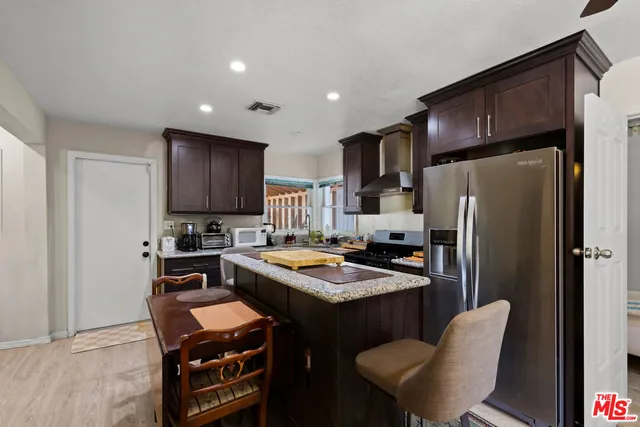 a kitchen with stainless steel appliances granite countertop a refrigerator stove microwave and sink