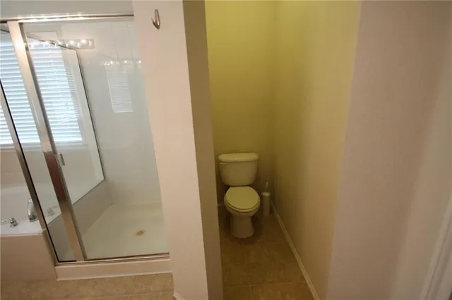 a bathroom with a white toilet and shower