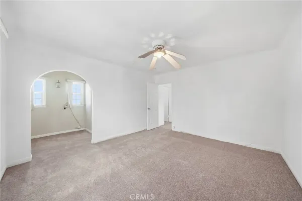 an empty room with chandelier fan