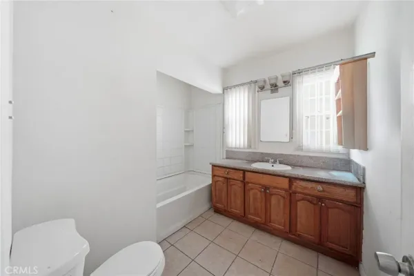 a bathroom with a granite countertop toilet a sink and a bathtub