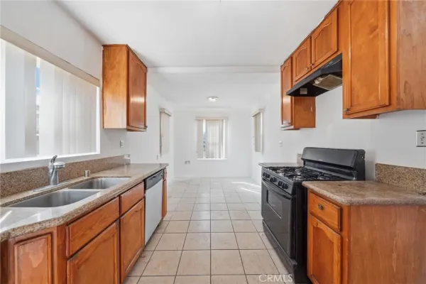 a kitchen with granite countertop a sink stove and cabinets