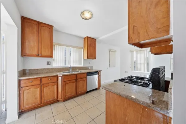 a kitchen with granite countertop cabinets and stove top oven