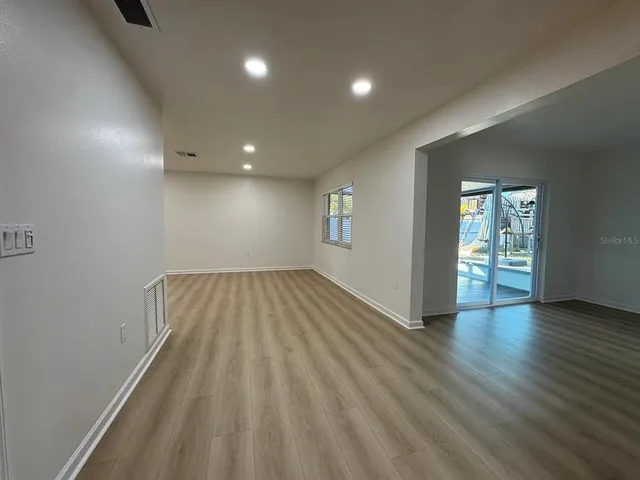 wooden floor in an empty room with a window