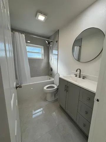 a spacious bathroom with a double vanity sink toilet mirror and window