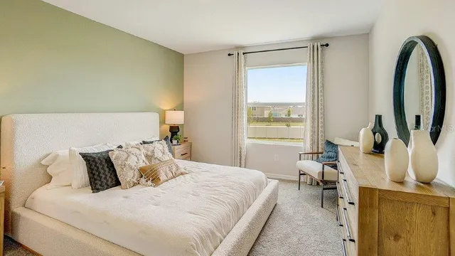 a bedroom with a bed a mirror and a large window